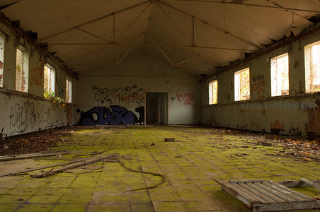 废弃厂房内部，涂鸦与青苔覆盖的荒凉空间