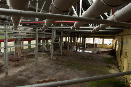空旷厂房中交错的管道与支撑柱