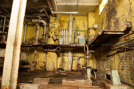 废弃工厂锈蚀管道与斑驳黄墙