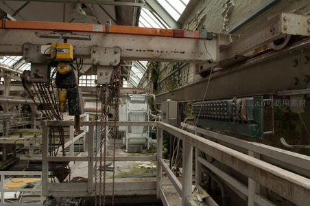 特写废弃工厂中悬挂的起重机与控制面板