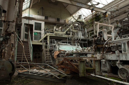 废弃造纸厂内布满灰尘的大型机器