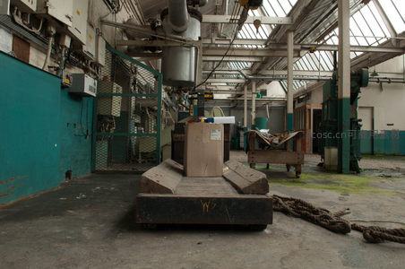 空旷车间内大型机器静默，绳索散落地面