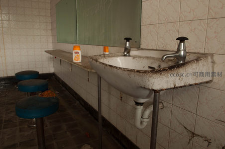 脏污洗手池旁小凳，镜面模糊见证岁月