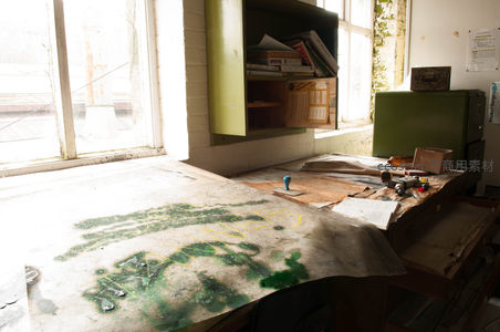 废弃工作台绿漆斑驳，工具散落窗边