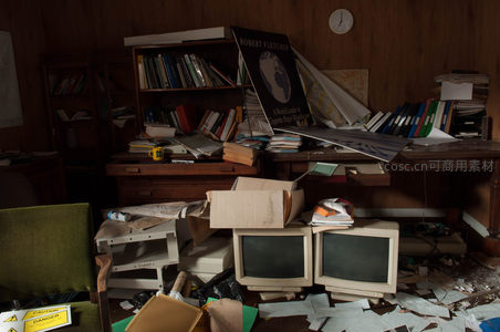 老式电脑与书籍堆满的废弃办公角落