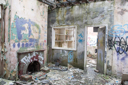 废弃房屋内部，墙壁剥落涂鸦遍布