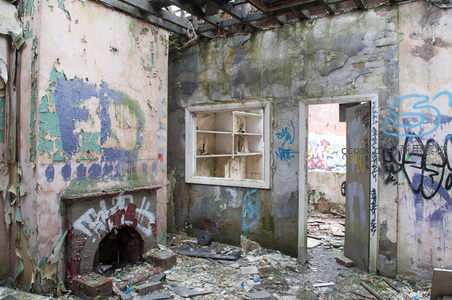 破败房间角落，壁炉残骸与涂鸦墙