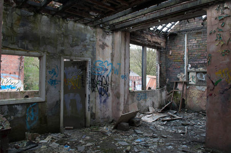 空旷废屋大厅，立柱涂鸦与残窗