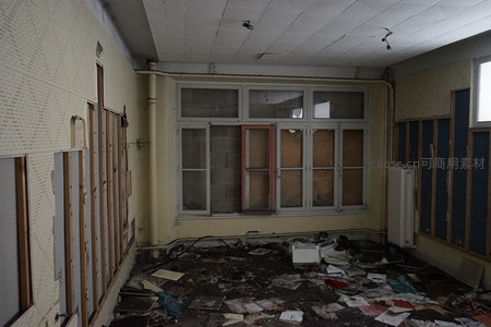 废墟教室满地纸张，窗棂斑驳透出时光痕迹
