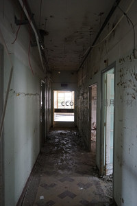 幽深走廊尽头透光，墙壁剥落电线裸露