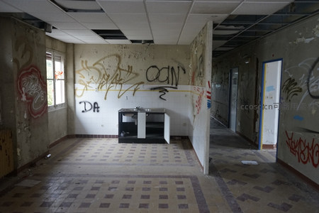 空旷废弃房间内景，涂鸦覆盖墙壁与橱柜