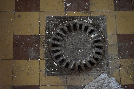 嵌在地砖中的圆形排水井盖