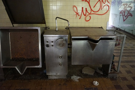 废弃厨房角落的生锈设备与涂鸦墙