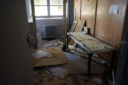 废弃教室的破败景象，桌椅倾倒满地狼藉