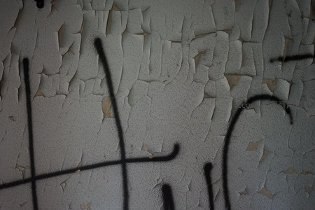 斑驳墙面特写，黑色涂鸦划过龟裂漆皮