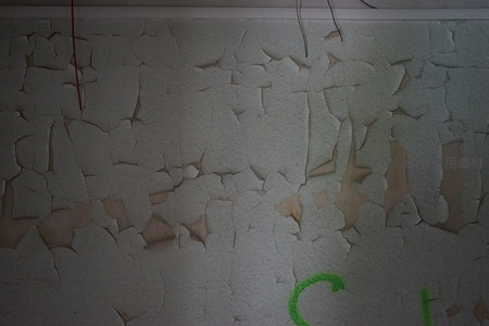 老旧墙皮剥落细节，绿色涂鸦点缀其间