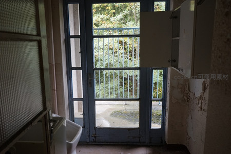 废弃厨房门洞外绿意盎然的对比景象