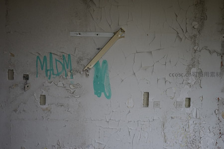 破败墙壁上的绿色涂鸦与金属残骸