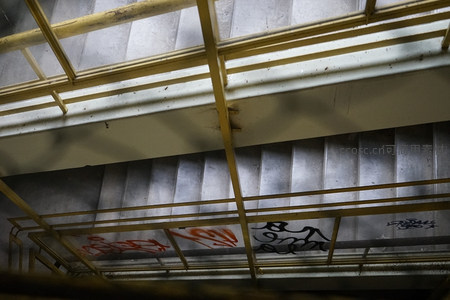 楼梯间金属栏杆下的涂鸦光影