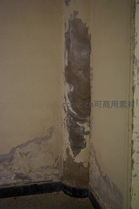 墙角漆皮剥落显露出灰色水泥基底