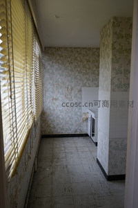 废弃厨房角落，旧墙纸与百叶窗的时光印记