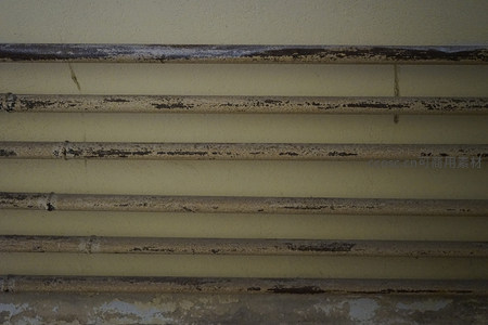 锈迹斑斑的管道与剥落墙面特写