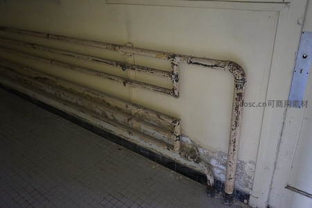 斑驳管道沿墙延伸，诉说岁月痕迹
