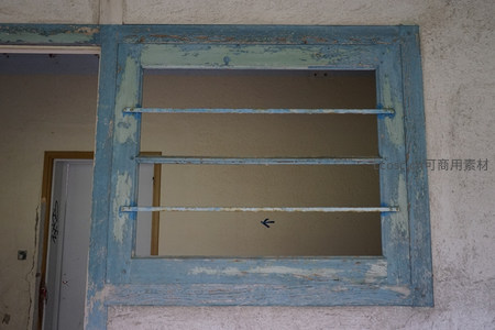 蓝色窗框油漆剥落，内有金属栏杆