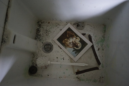 废弃水槽内积满污垢与宗教画片