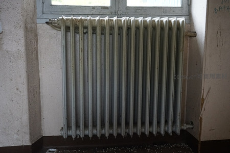 老旧铸铁暖气片在斑驳墙边