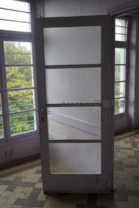 废弃房间的旧门与窗外绿意