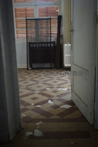 从门口望向空荡走廊与老式床架