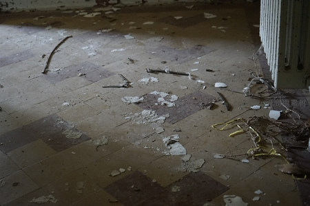 阳光斜照下满是碎屑的破旧地板