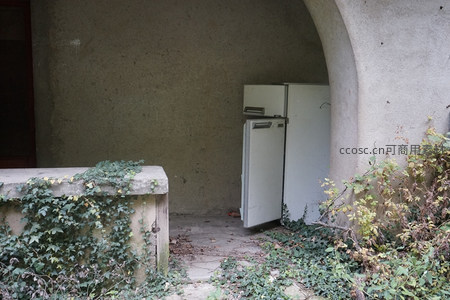 废弃冰箱倚靠拱门角落