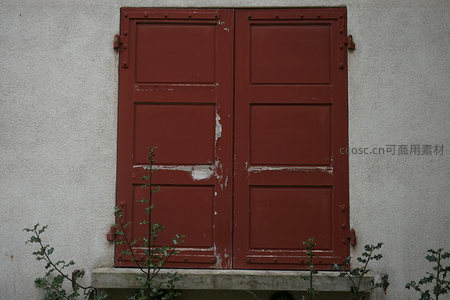 红色百叶窗下的野草丛生