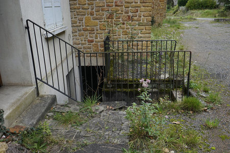 石墙旁的废弃入口，铁栅栏围起的角落