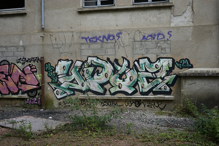 绿白涂鸦与蓝色文字，点缀破败墙体
