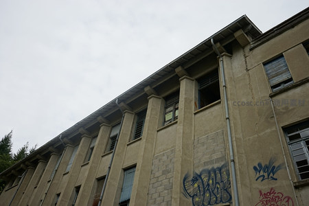 仰拍视角下带涂鸦的旧楼屋檐