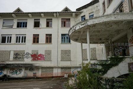 圆形门廊与涂鸦覆盖的废弃楼群
