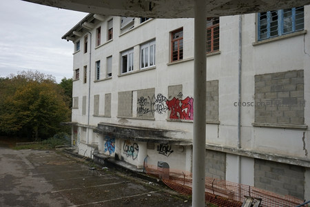 白色旧楼外墙斑驳，涂鸦点缀显沧桑