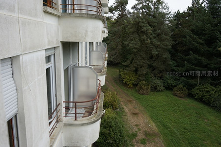 俯瞰公寓楼侧，绿茵草地与森林相接