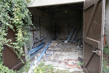 废弃车库内杂乱的金属构件与爬藤植物