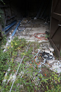 荒芜庭院中散落的塑料瓶与野草丛生