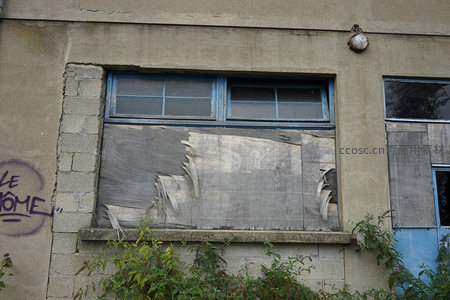 破败外墙窗户被木板封堵的景象