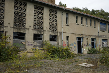 长条形废弃建筑，几何窗格与涂鸦并存