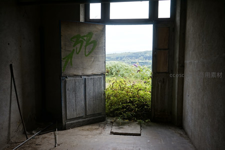 废弃房间内望，门外绿野与远山相接