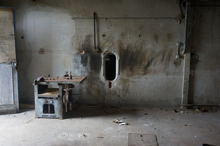 老旧车间角落里生锈的机床与烟熏墙壁