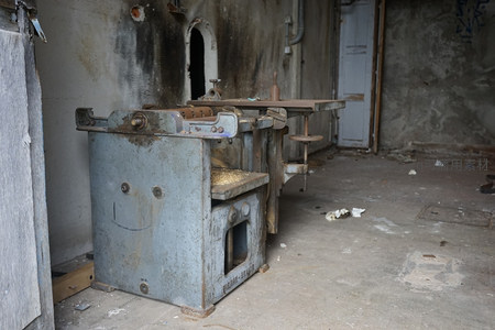 破旧车间内孤零零的蓝色工业设备特写