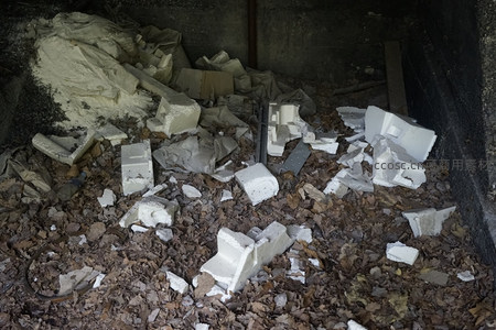 废墟角落堆积的白色泡沫块与落叶垃圾