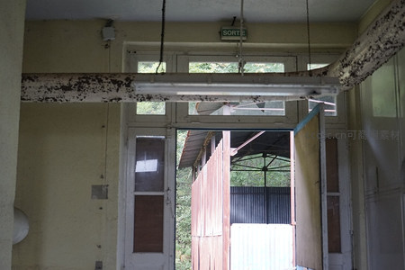 破败门廊视角下的锈管与出口标识